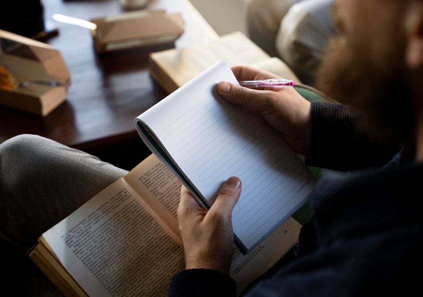 Imagen del evento:Persona sentada encima de un libro gigante haciendo como que pesca una letra de la portada